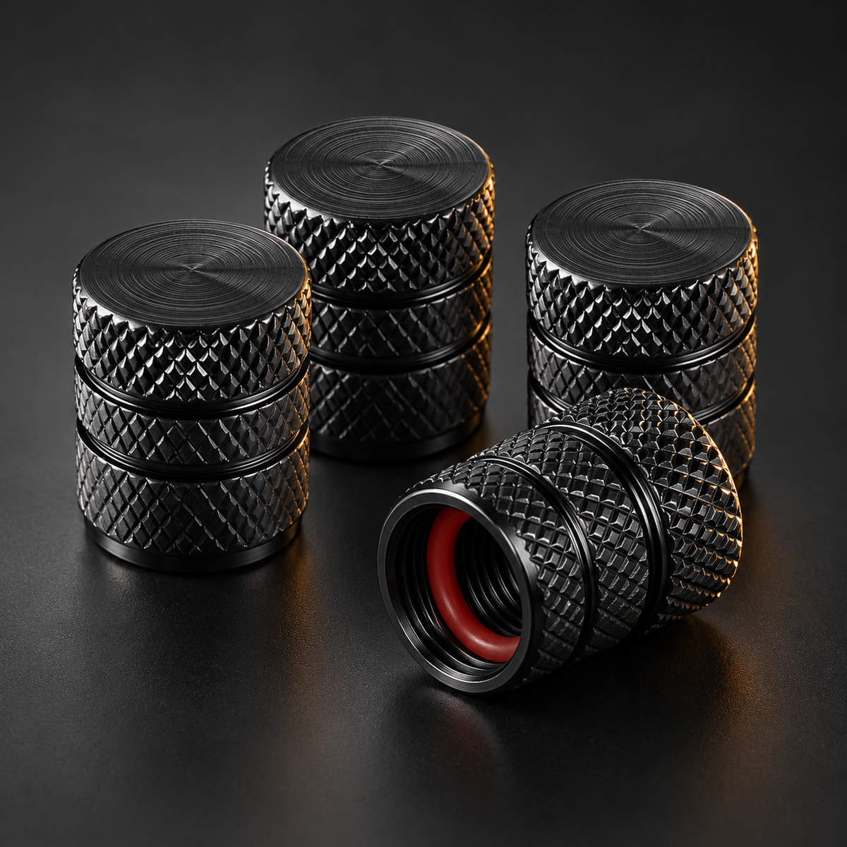 Bouchons de valve moto en aluminium noir moleté, l'un couché montrant son joint torique