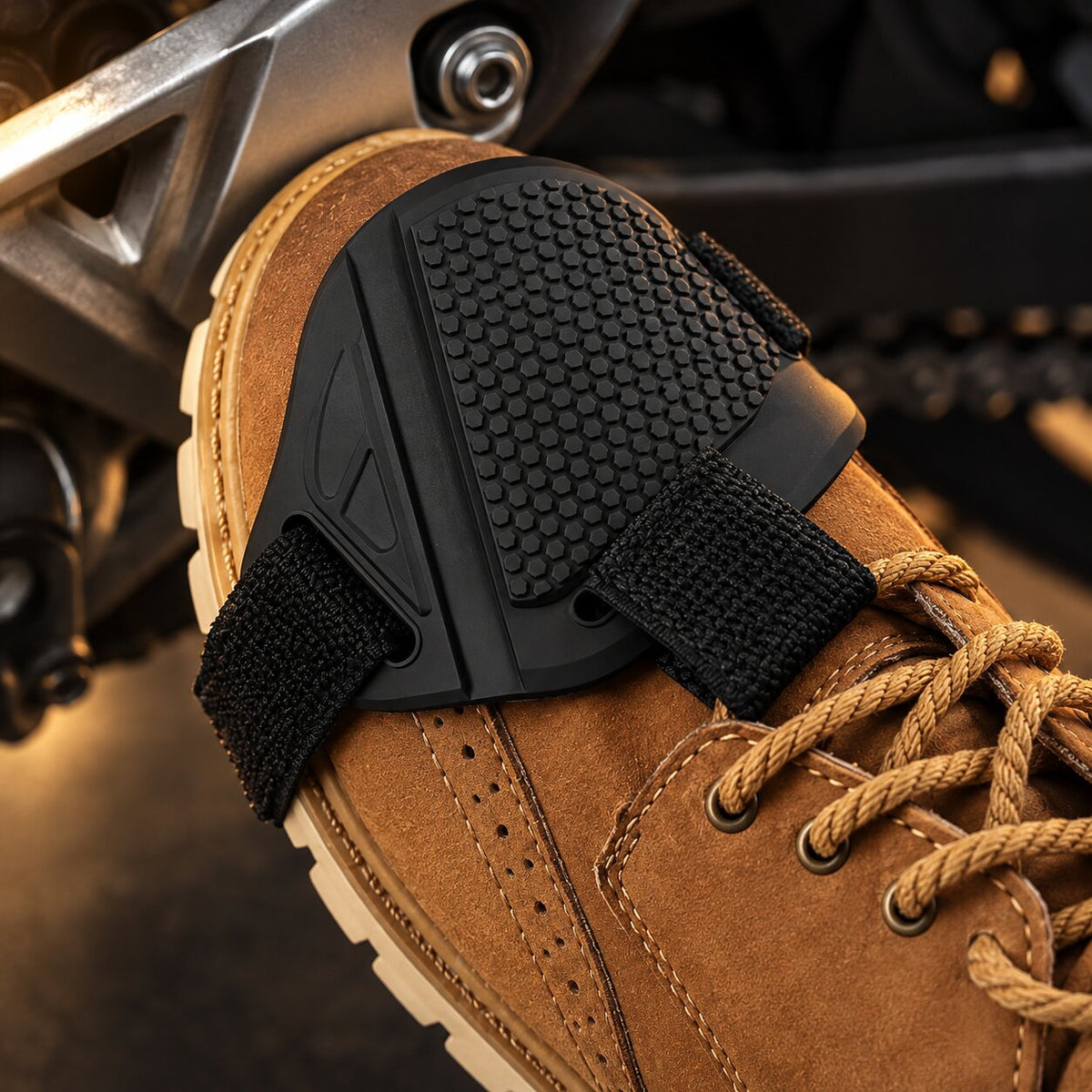 Protège-chaussure moto noir porté sur une chaussure en cuir, au contact du sélecteur de vitesse